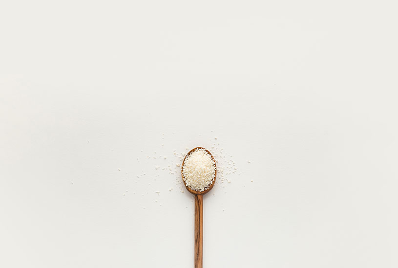 wooden spoon full of salt in white surface