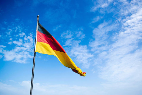 German flag raised high in somewhat clear skies