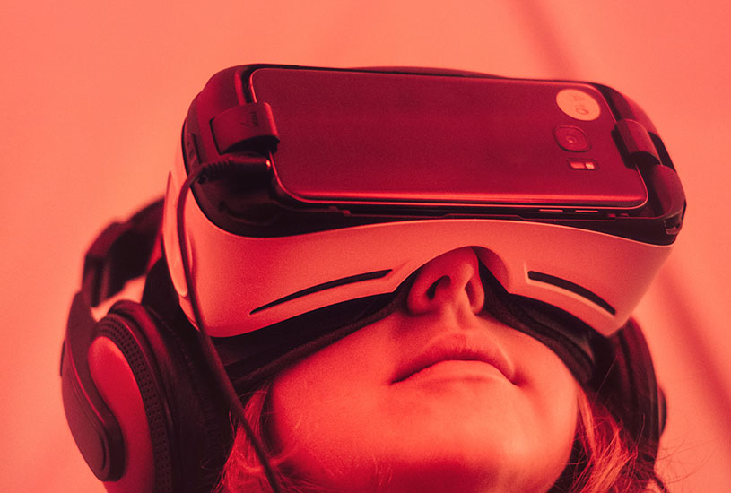 person looking up and wearing a virtual reality headset with red lighting