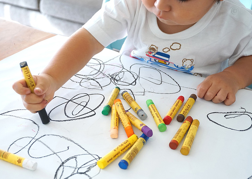 Child drawing with crayons
