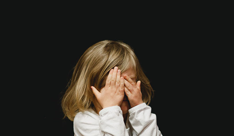 girl covering her face with both of her hands
