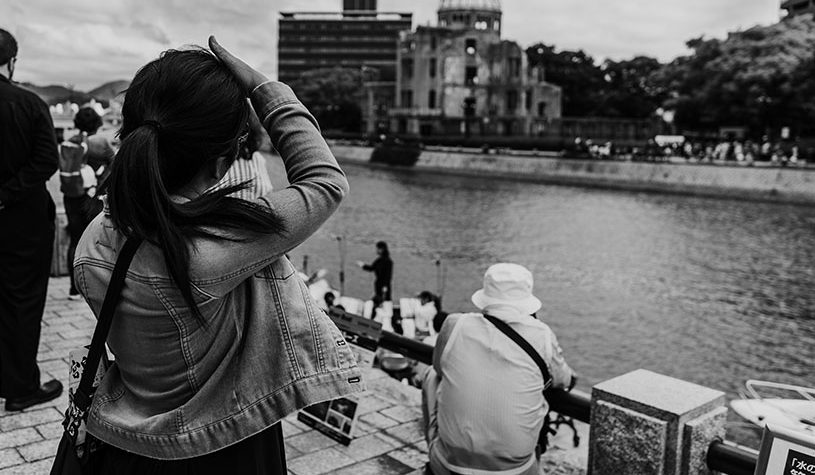 black and white woman looking at a building across the river