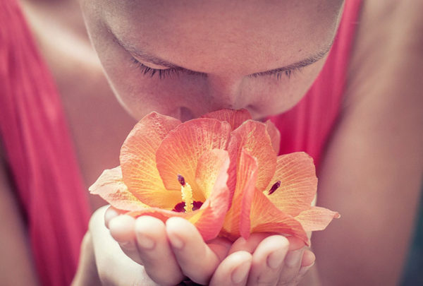 Woman smelling a red flower