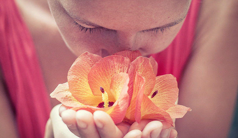 Woman smelling a red flower