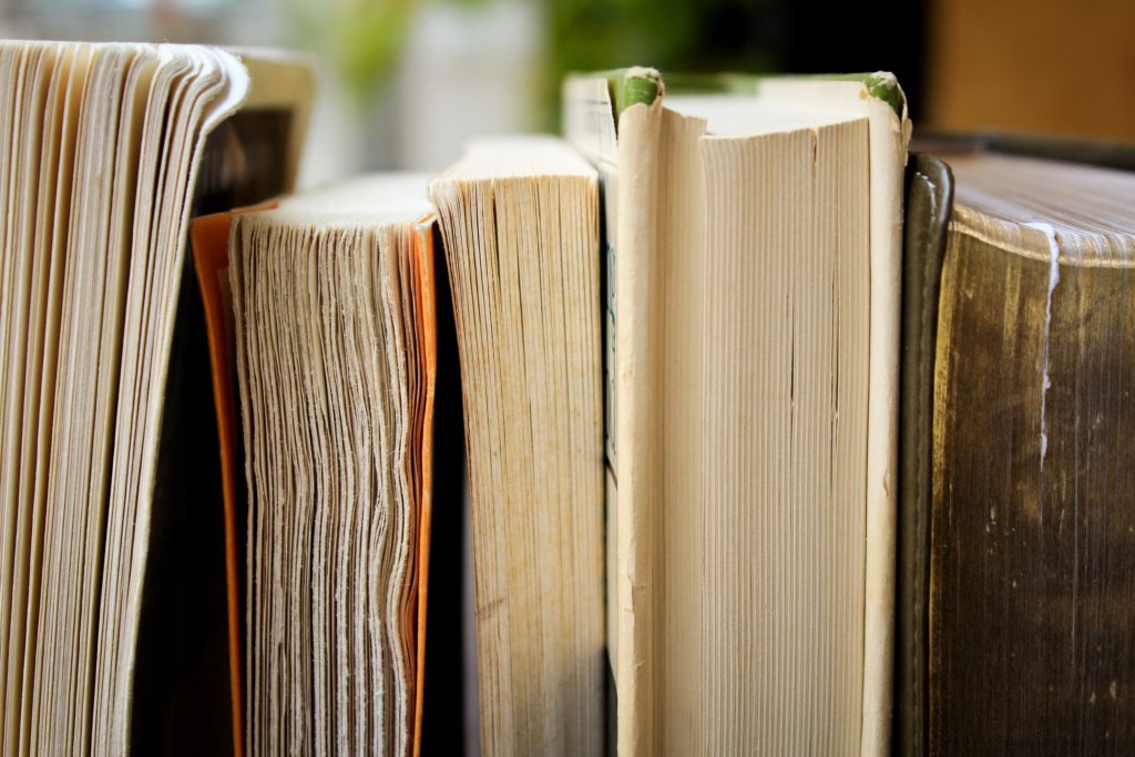 Books stacked side by side with crinkled pages facing forward.
