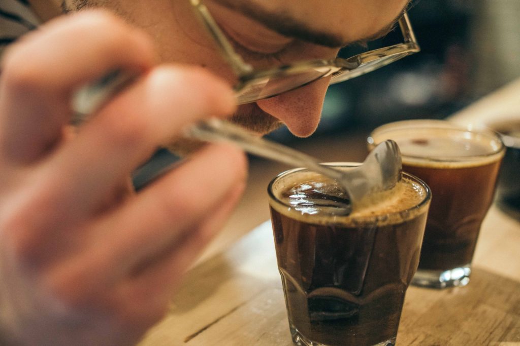 A close up of a man smelling freshly made coffee.