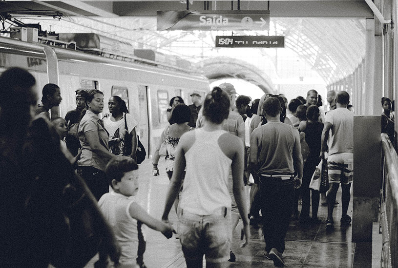 A black and white image of a crowded subway station.