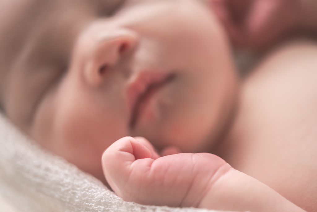 A close up portrait of a sleeping infant.