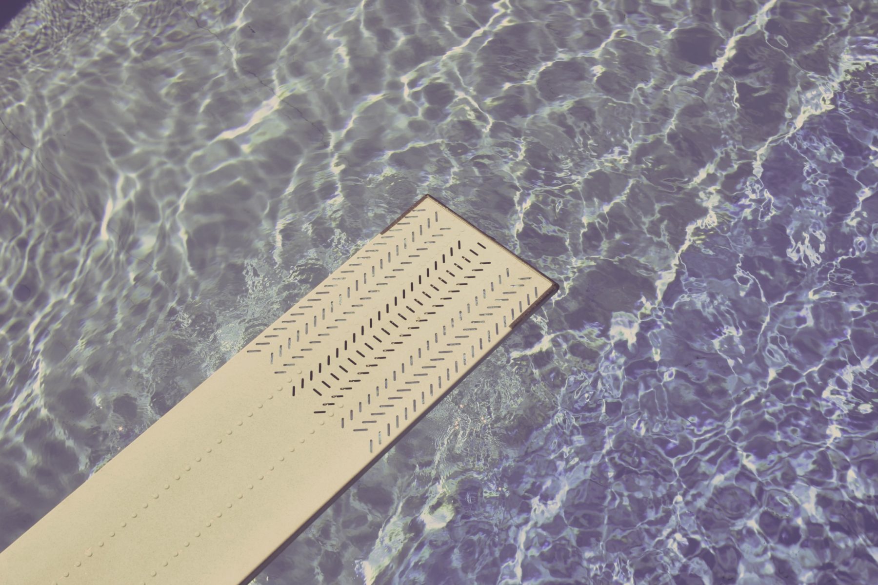 A diving board over a swimming pool.