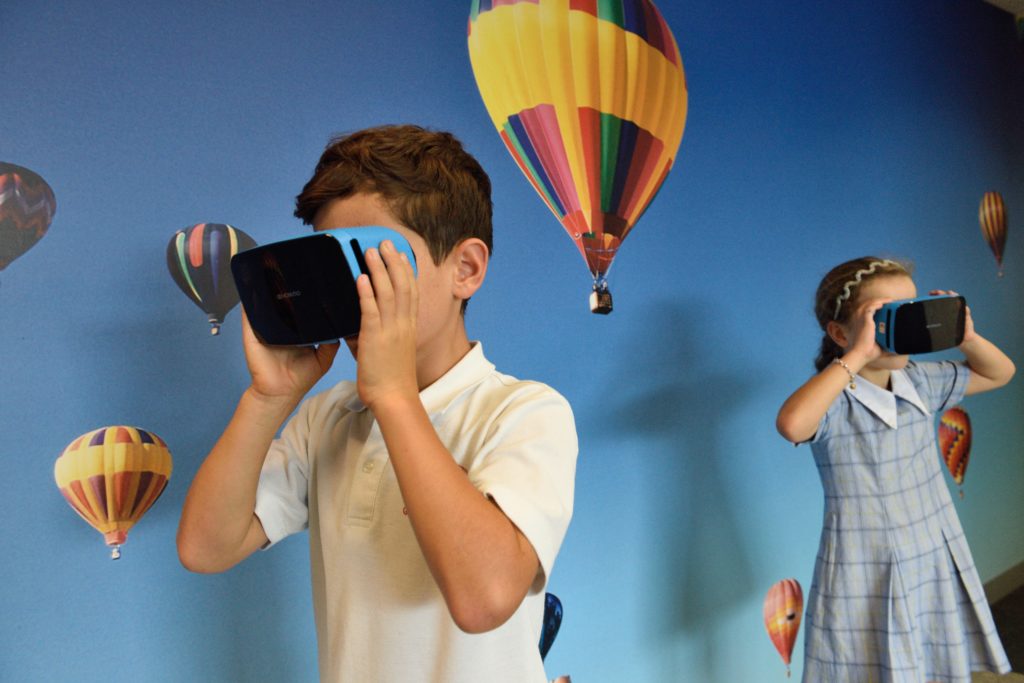 Two young students using virtual reality headsets.