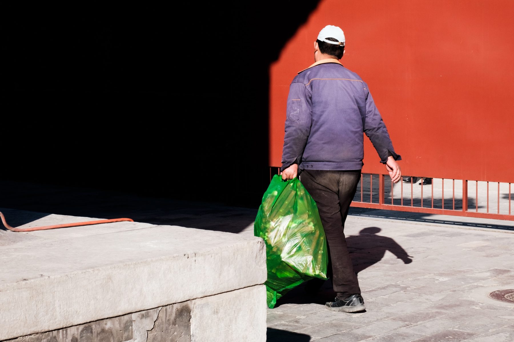 A man in Beijing carrying a bag of rubbish.
