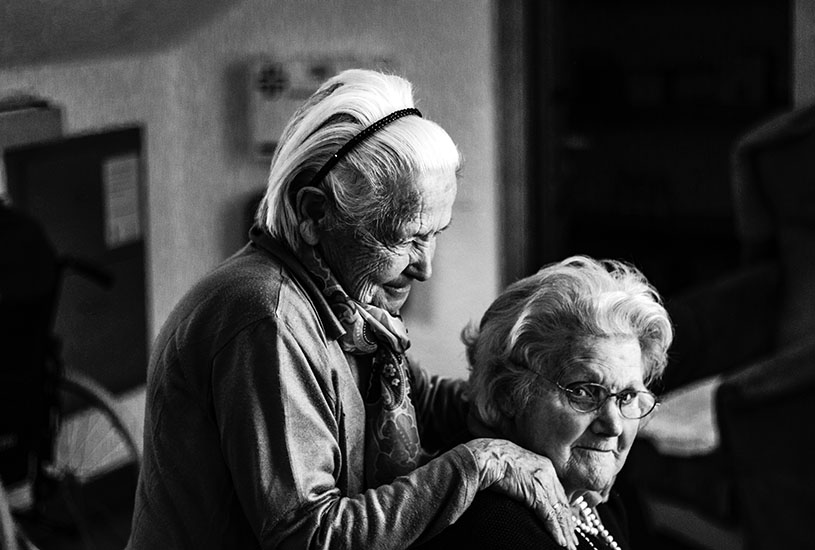 A mother and daughter sitting together in a retirement home.