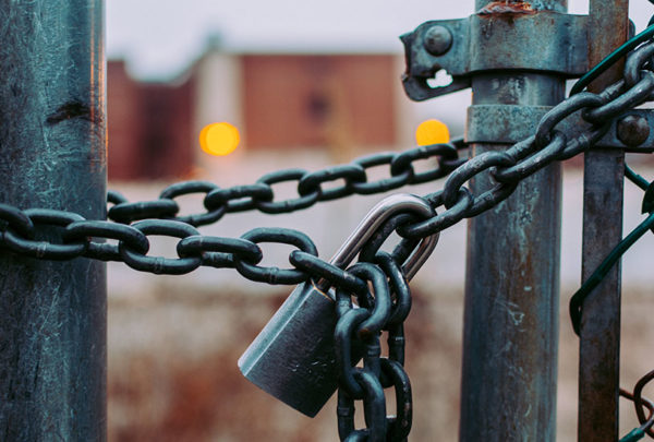 A chain and padlock holding a wired door together.