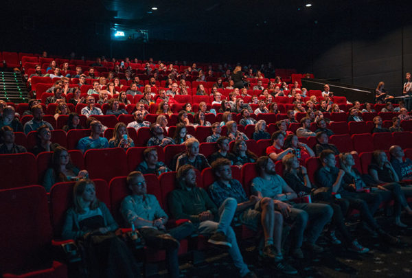 An audience sitting in a movie theatre.