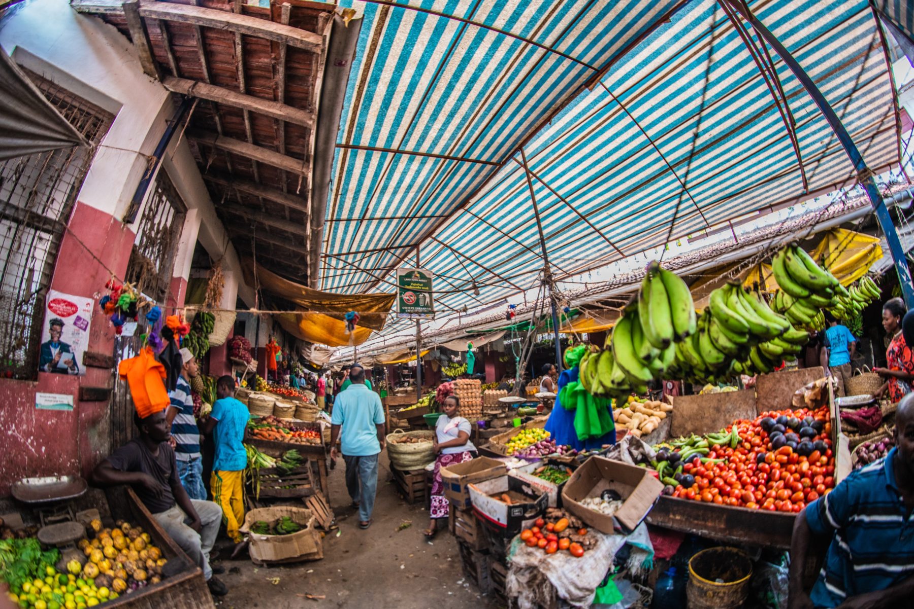 A Kenyan marketplace with fruits and vegetables filling the stalls.