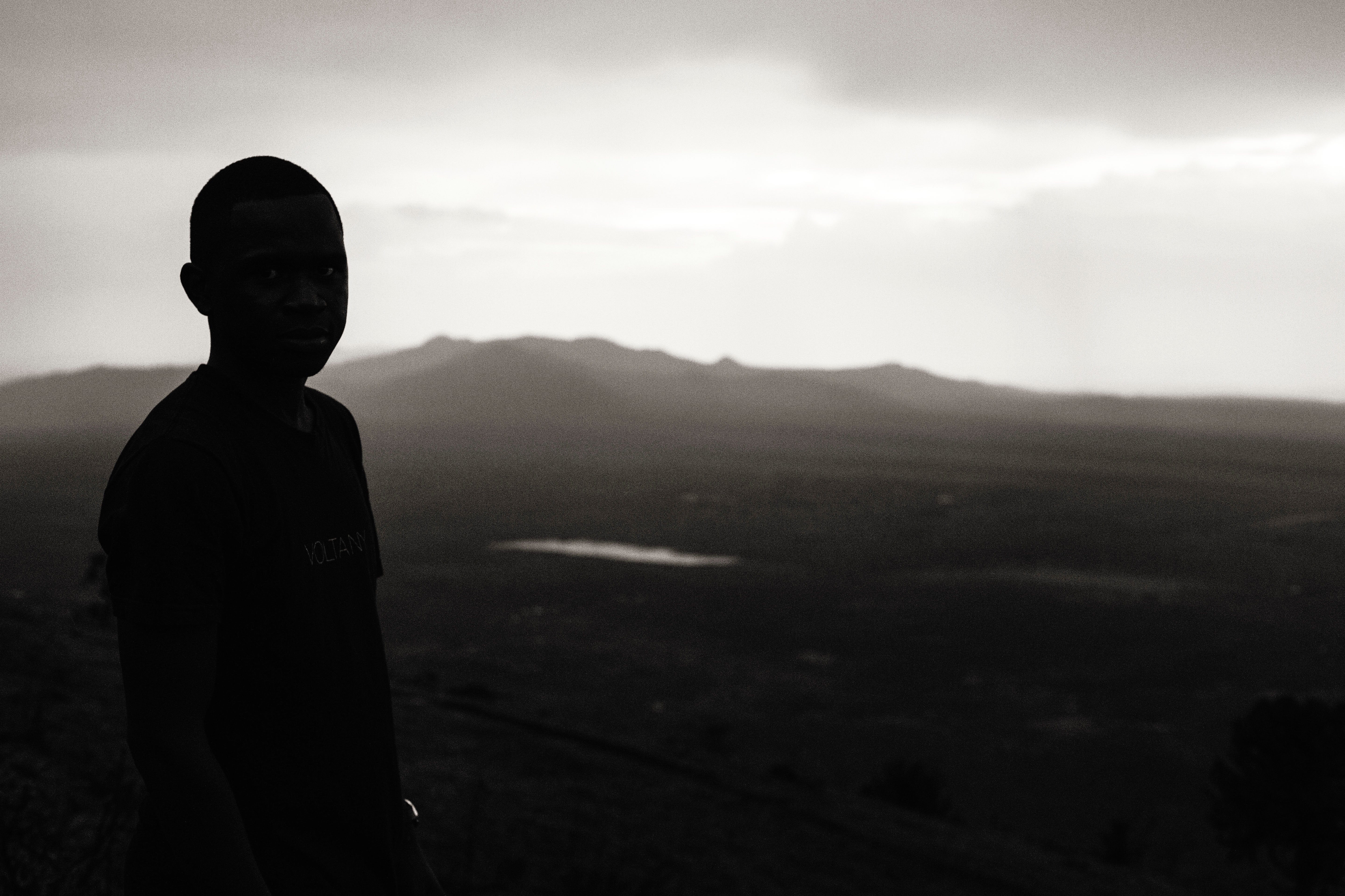 A young person staring out over the Kenyan countryside.
