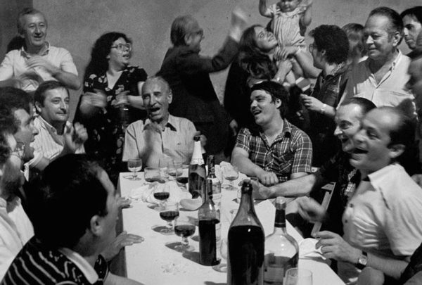 A group of people sitting around a table laughing and conversing.
