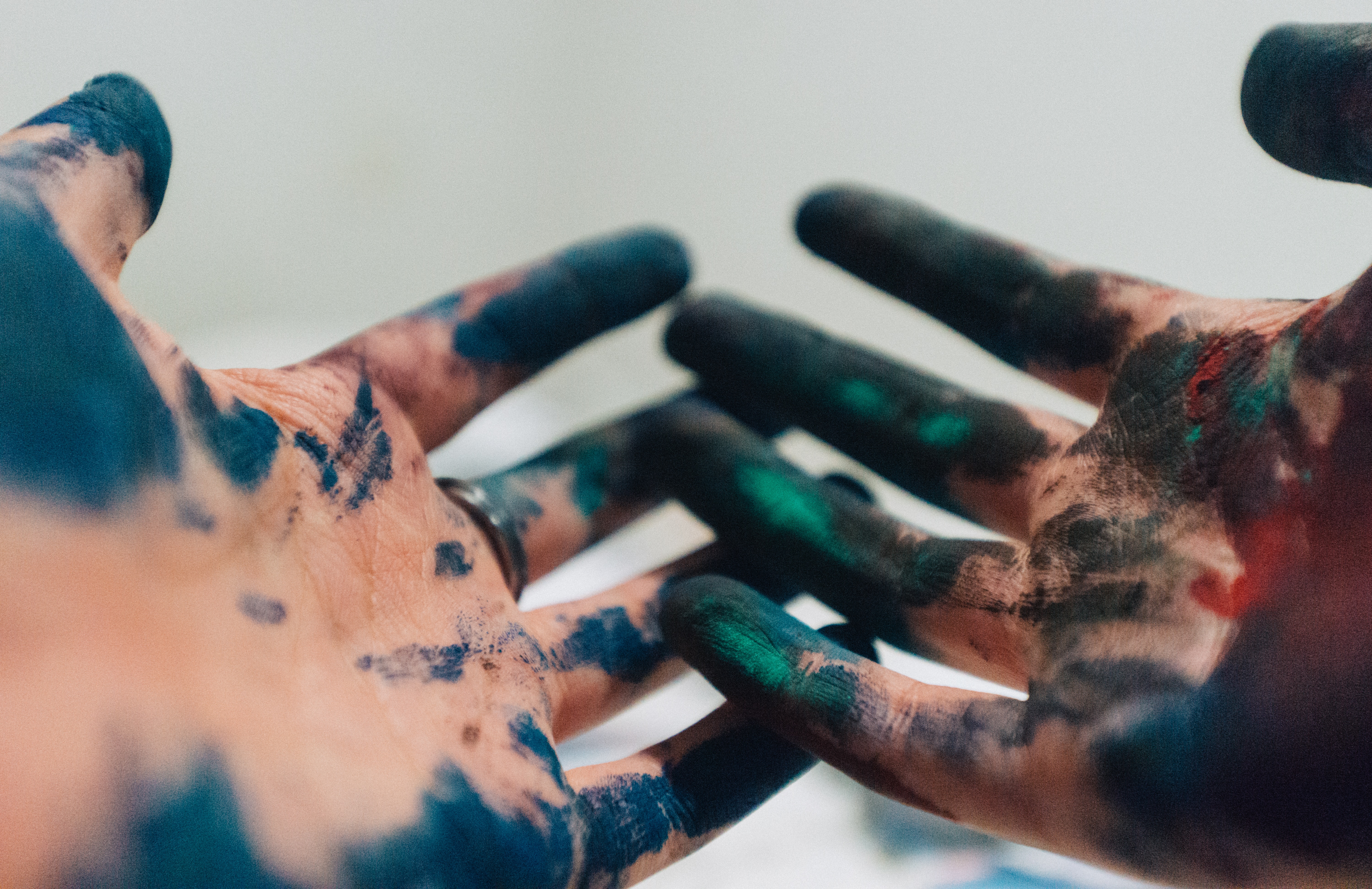 A pair of hands covered in paint.