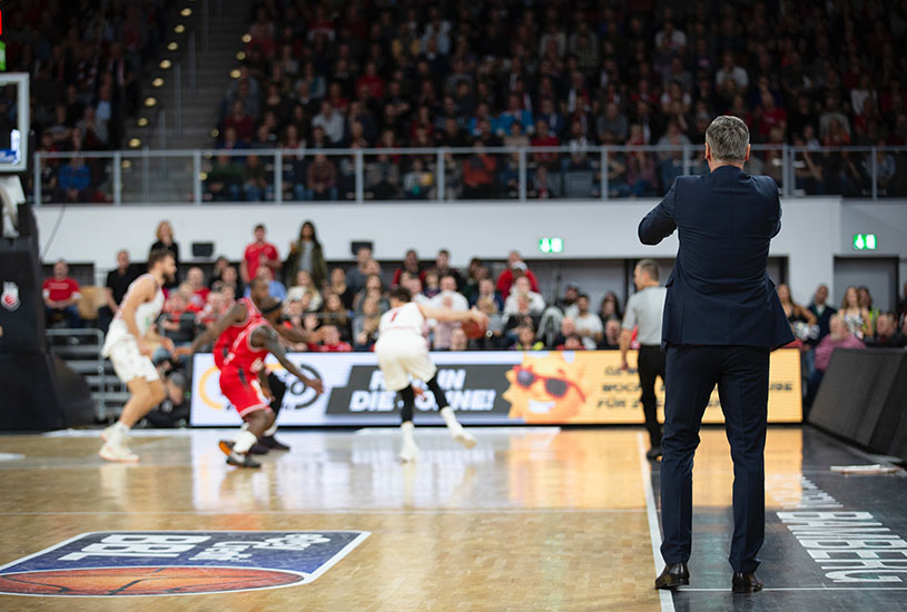 A basketball coach giving instructions from the touchline.