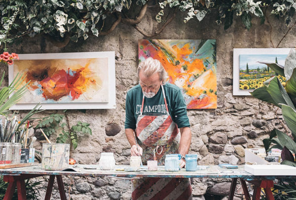 An artist painting on canvases.