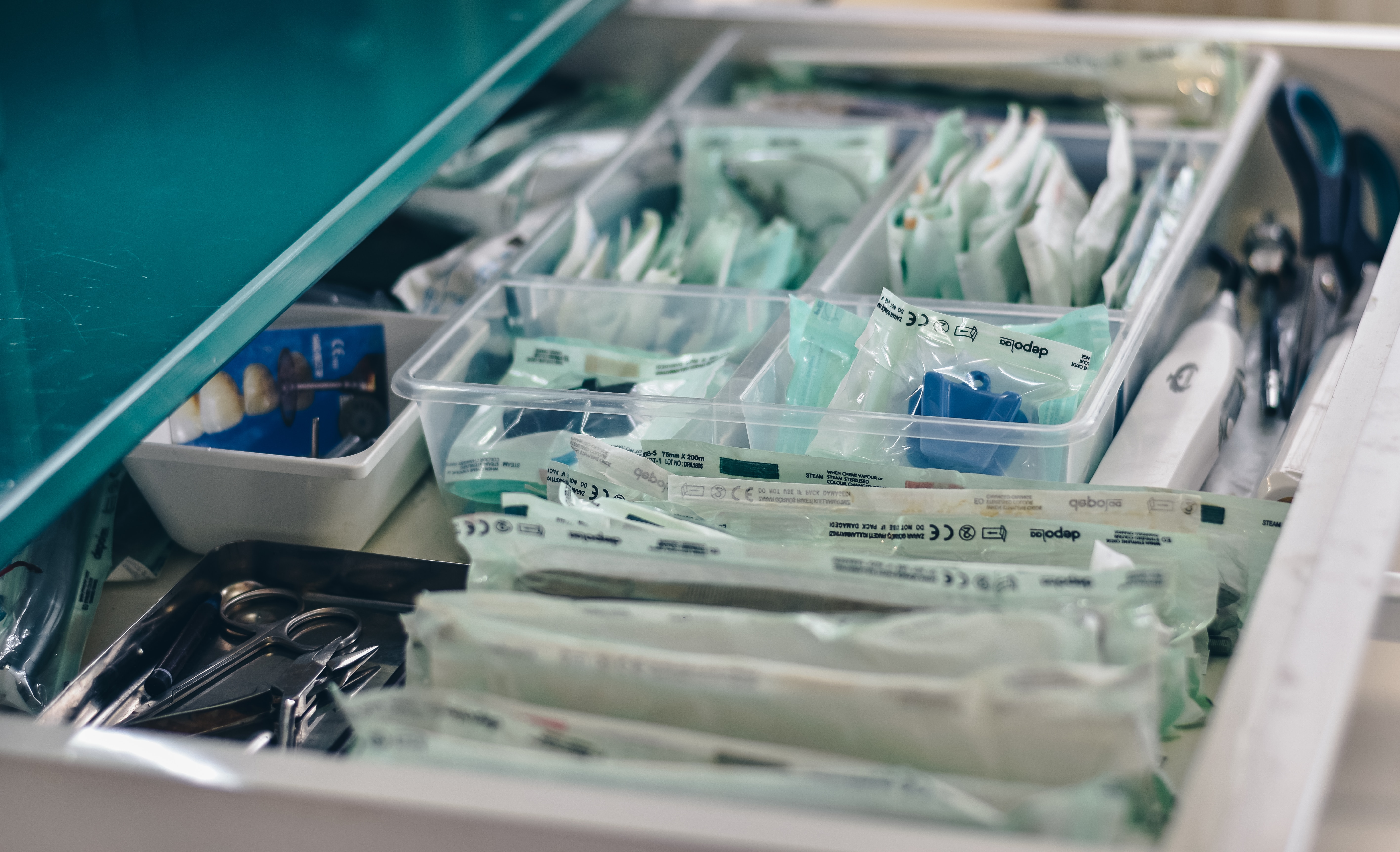 A drawer of hospital instruments packaged in plastic.