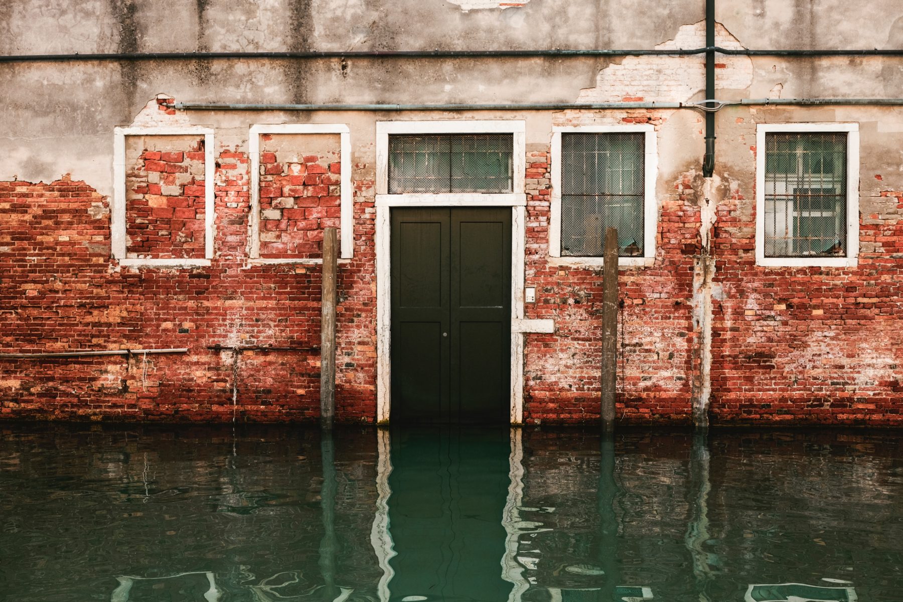 High waters against a red brick home in Venice, Italy.