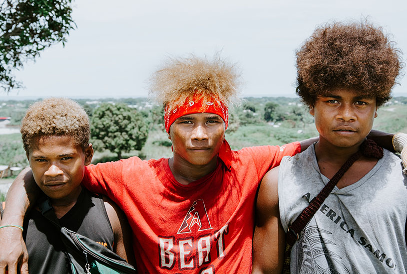 A portrait of three young boys from the Solomon Islands.