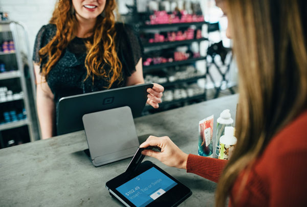 A woman making a transaction at the cashier of a store.