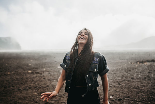 A young woman laughing while walking.