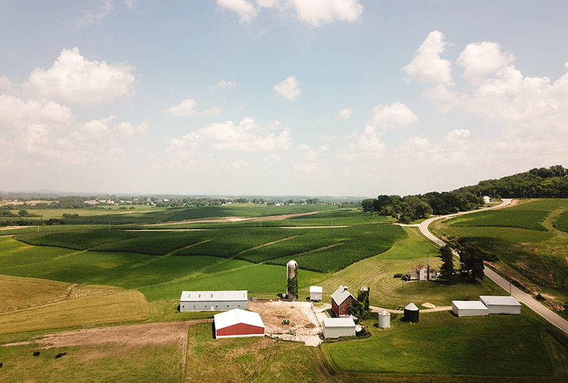 A farm house set against the green hills of the countrysiude.