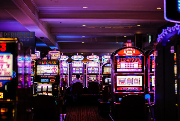 The inside of a casino with a row of pokies machines.