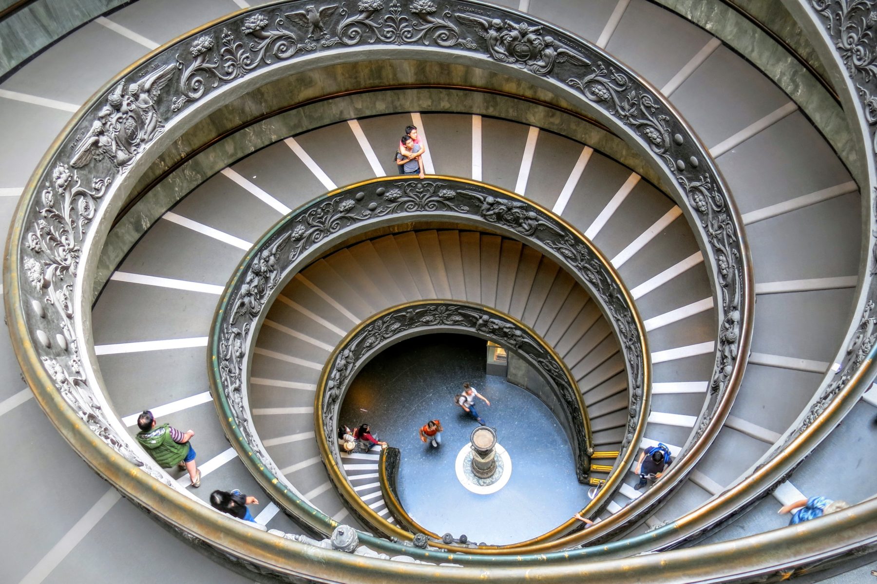 People walking down a spiral staircase at the Vatican Museum, Rome.