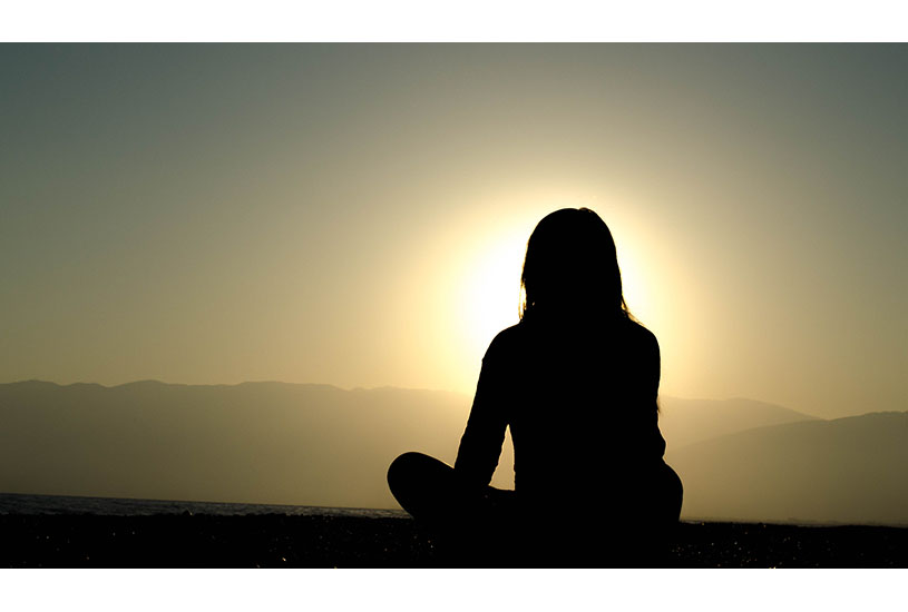 Image of woman silhouetted against the sun