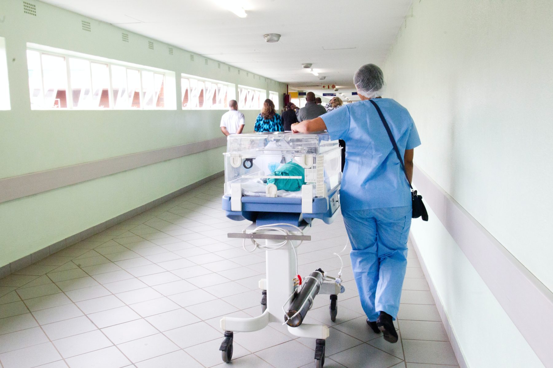 Image of a nurse pushing a gurney down a hall