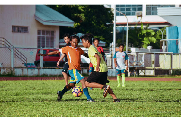 Image of children kicking a soccer ball