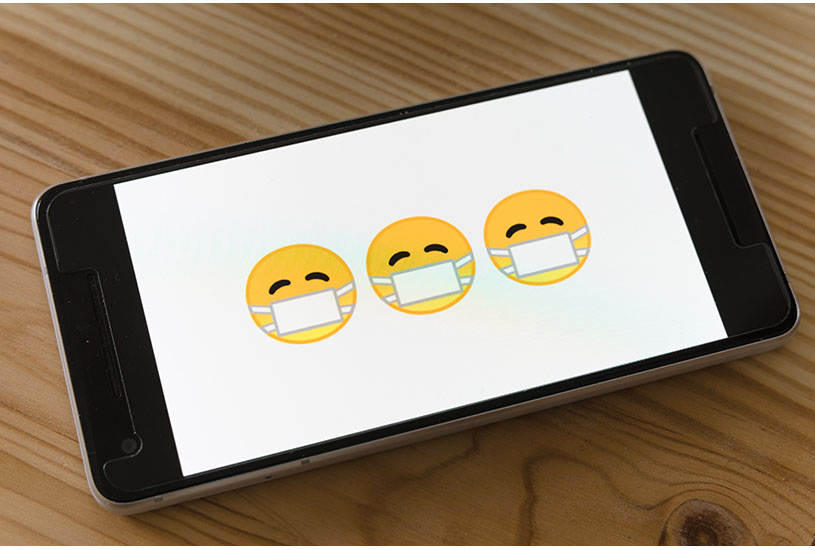 Image of smartphone with emojis of people wearing face masks