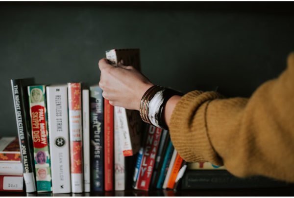 Image of a person reaching for a collection of books