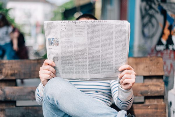 Image of a person reading a newspaper